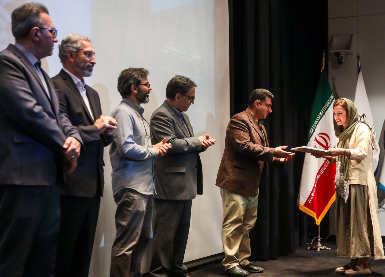 An artist (R) receives an award at the 11th National Biennial of Persian Painting at the Tehran Museum of Contemporary Art on April 29, 2023. (ISNA/Mohammadreza Bolandi)