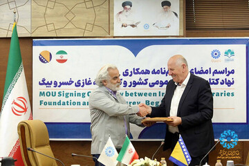 Iran Public Libraries Foundation deputy director Baqer Mirabdollahi and Gazi Husrev-bey Library director Osman Lavic shake hands after signing an MOU in Tehran on May 8, 2023. (Iran Public Libraries F