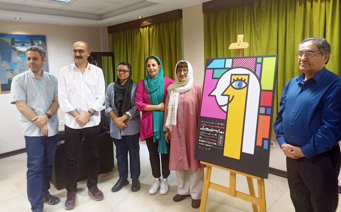 Organizers pose after unveiling a poster for the 19th edition of the Mobarak Puppet Theater Festival in Tehran on June 10, 2023.