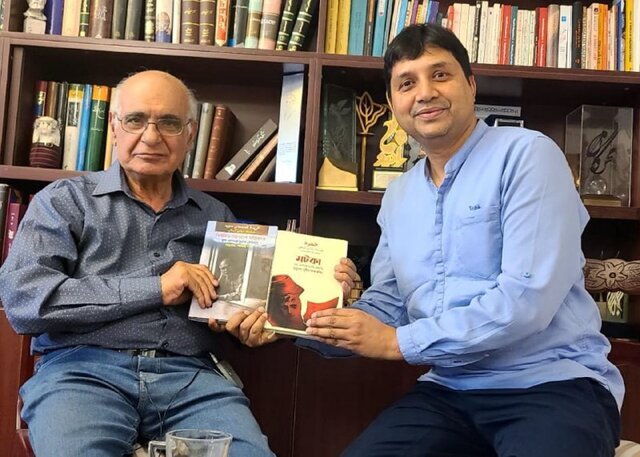 A file photo shows Iranian writer Hushang Moradi Kermani (L) and Bangladeshi translator Muhammad Mumit Al-Rashid holding copies of the Bengali translation of “Water Urn” and “The Stories of Majid”.