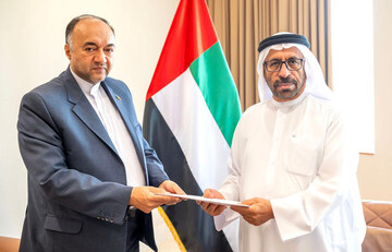 Iran's ambassador (L) submits letter of invitation to UAE Minister of State