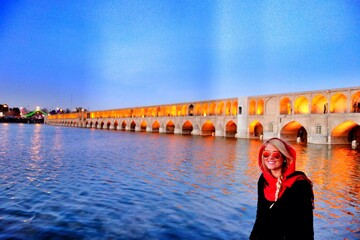 A traveler poses for a photo during her visit to Si-o-se-pol, a 17th-century gigantic arch bridge in Isfahan, central Iran.