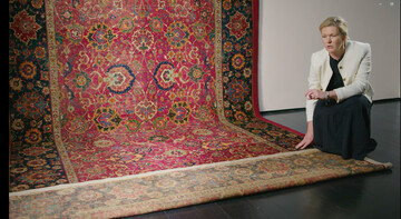 Louise Broadhurst, Christie’s head of Rugs & Carpets, sits beside a 400-year-old Persian carpet, during her presentation of the majestic work set to go on sale at the British auction house in London with a pre-sale estimate of £2-3 million.