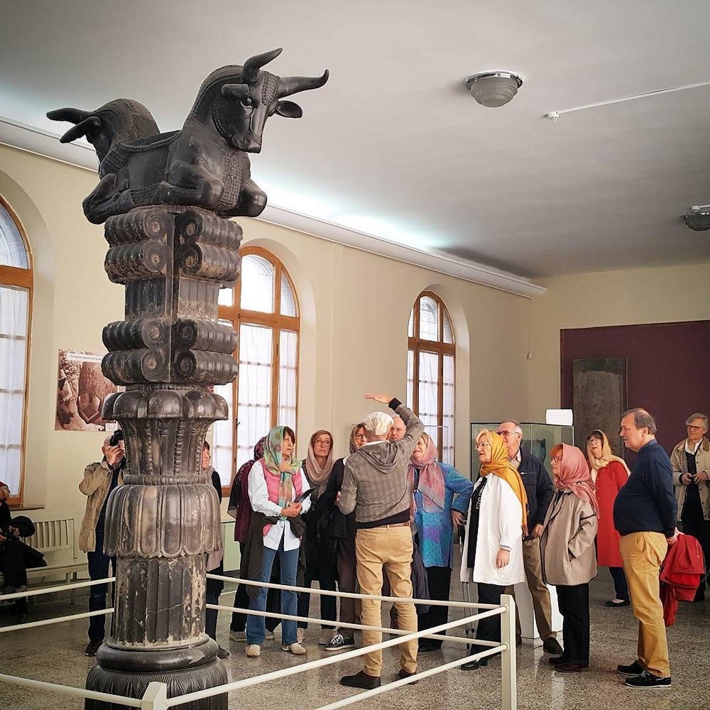 People visit the upper part of an imposing capital at the National Museum of Iran. The massive stone object was once been instated at Persepolis, the ceremonial capital of the Persian Achaemenid Empire (ca. 550-330 BC).