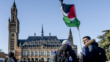 A demonstrator waves the Palestinian flag in front of the Peace Palace of the ICJ