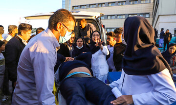 Paramedics carry a man injured in a deadly terrorist attack in the city of Kerman in southeast Iran