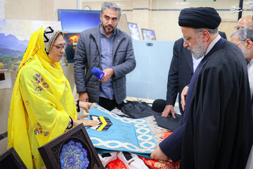 An undated photo depicts the late Iranian President, Ebrahim Raisi (R), talking to a craftswoman at a handicrafts exhibition in Shahrekord