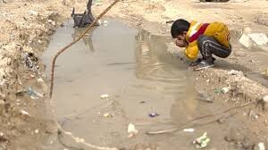 Palestinian boy in Gaza drinks from puddle
