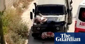 A Palestinian is tied to the hood of a vehicle