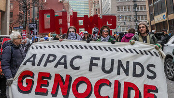 Demonstrators carry placard saying AIPAC funds genocide in Gaza