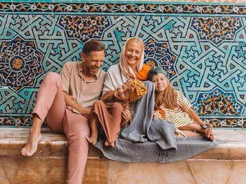 File photo depicts a foreign family posing for a photo during their visits to the 12th-century Jameh Mosque of Yazd in central Iran.