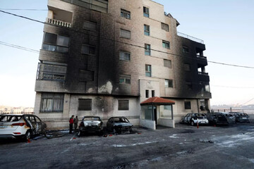 Damaged cars and burnt buildings show the aftermath of Israeli settler arson attacks in the West Bank city of al-Bireh