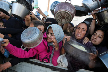 Palestinians gather to receive food from a charity kitchen amid Israeli-imposed starvation in Khan Younis in the southern Gaza Strip on November 19, 2024 [Hatem Khaled/Reuters]