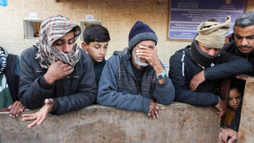 Palestinians mourn those killed in Israeli strikes at Al-Aqsa Martyrs Hospital in Deir al-Balah, central Gaza, 15 January (Reuters/Ramadan Abed)