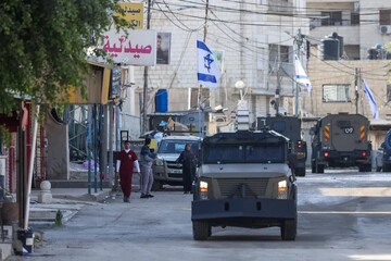 Israeli troops in armored vehicles carry out a raid in Jenin in the occupied West Bank on January 21, 2025 [Jaafar Ashtiyeh/AFP]