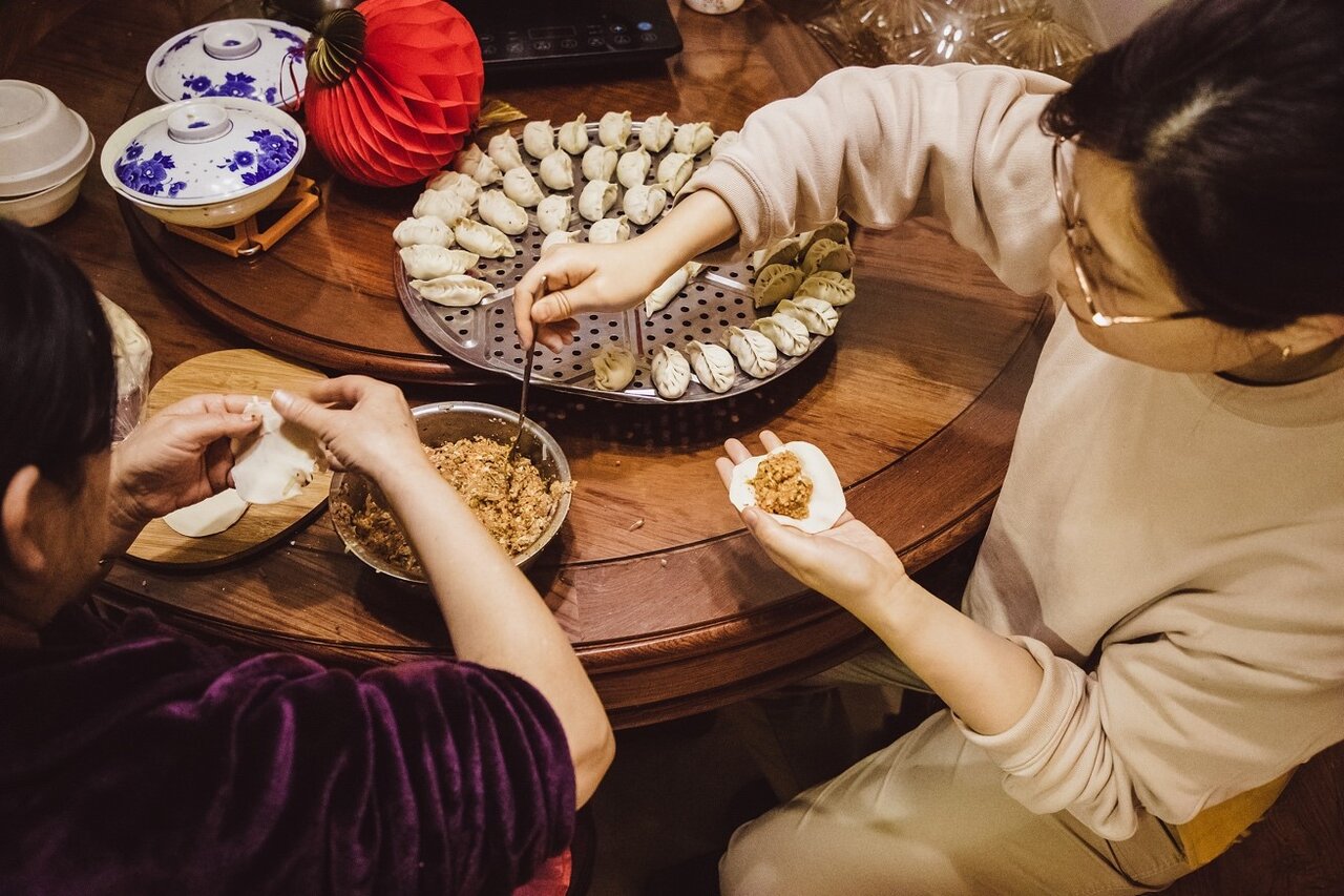 ​    ​Families make dumplings for celebrating the Spring Festival. /VCG