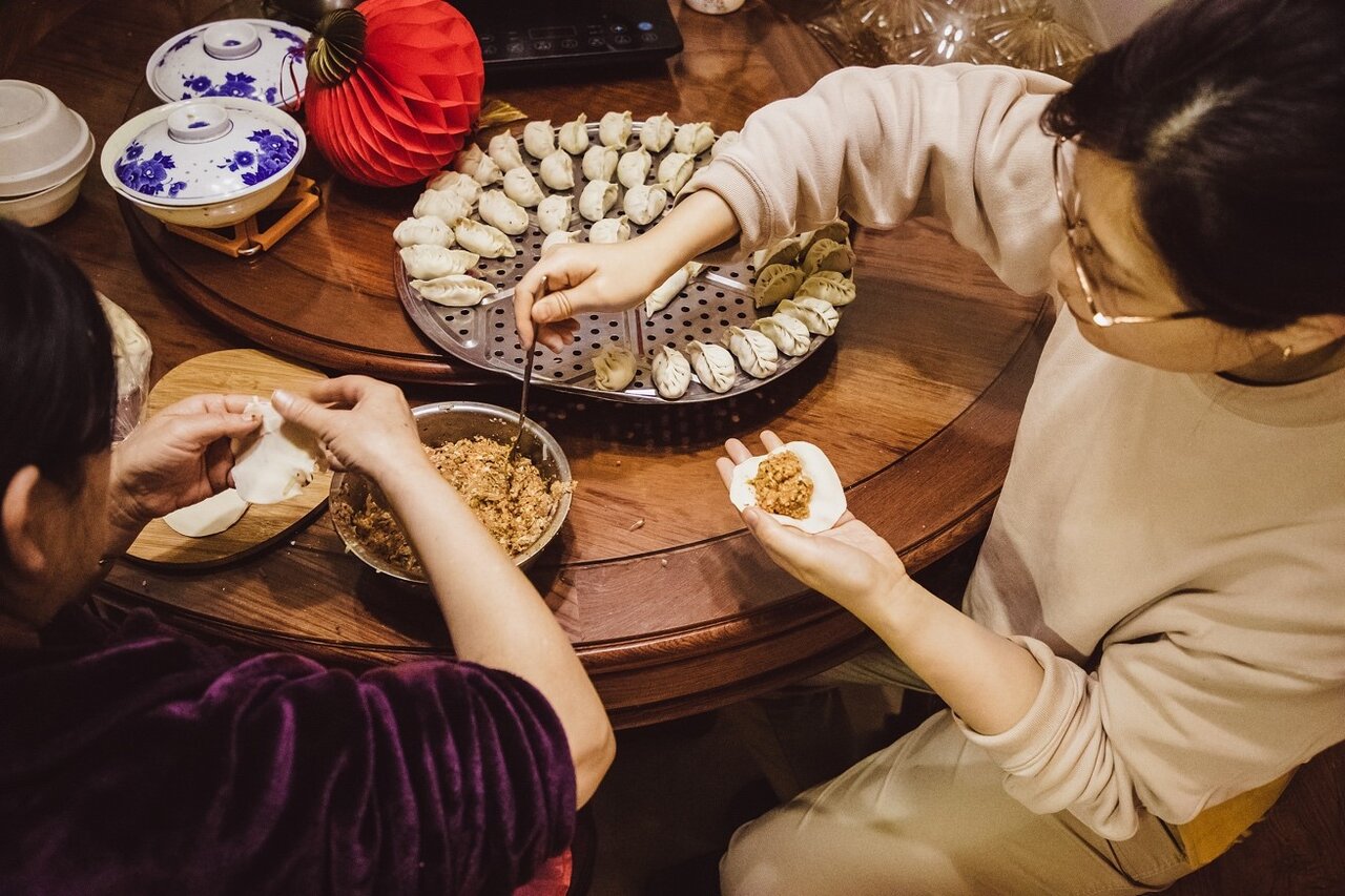     Families make dumplings for celebrating the Spring Festival. /VCG
