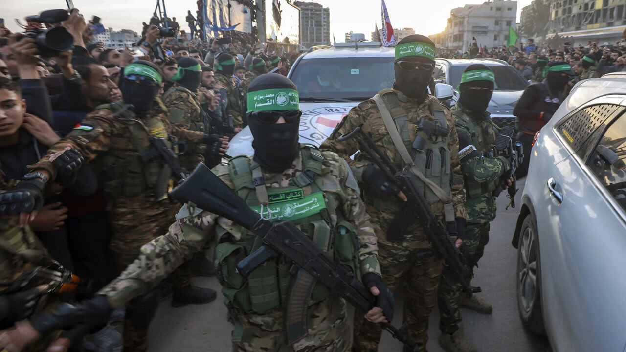 Hamas fighters escort a Red Cross vehicle to collect Israeli captives released after a ceasefire agreement between Israel and Hamas took effect, in Gaza City on Sunday, Jan. 19, 2025. Abed Hajjar/AP