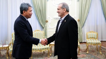 Malaysian FM Mohammad Hasan shakes hand with Iranian President Pezeshkian