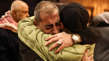 A former Palestinian prisoner (right) is welcomed by relatives upon arrival in the occupied West Bank city of Ramallah on 27 February 2025 as part of the final batch of released detainees in phase one