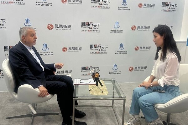 Iran’s tourism minister Seyyed Reza Salehi-Amiri (L) talks to a Chinese media personnel in an interview with PhoenixTV News on the sidelines of the AIM Congress 2025 in UAE, April 8, 2025.