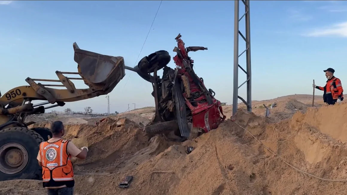 Search crews use a bulldozer to search for the victims through sand in southern Rafah.