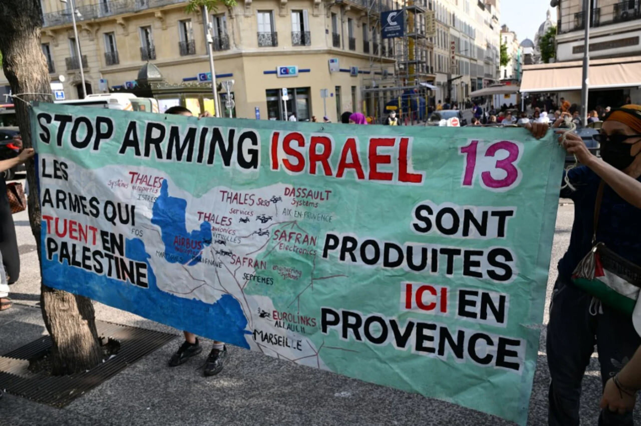 Demonstrators install a banner reading "The weapons killing in Palestine are produced here in Provence" at a gathering against a shipment of Eurolink military equipment parts set to go to Israel, in M