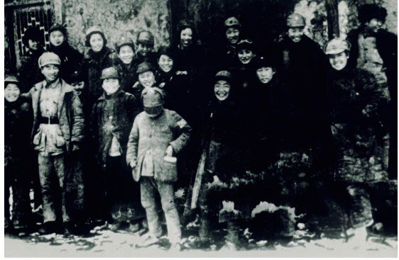 This scanned copy of a file photo taken by American journalist Agnes Smedley in February of 1940 shows Sheng Guohua (front row, looking down) posing for a group photo with some members of a children's troupe that accompanied the New Fourth Army's Henan-Hubei Detachment (the predecessor of the Fifth Division) at its base in central China's Hubei Province. (New Fourth Army's Fifth Division Memorial/Handout via Xinhua)