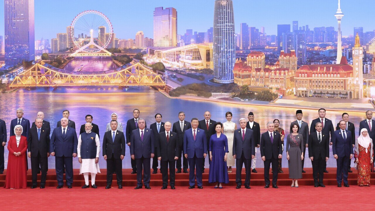 In this photo released by Xinhua News Agency, Chinese President Xi Jinping and his wife, Peng Liyuan, center pose for a group photo with international guests including Russian President Vladimir Putin, seventh from left, Indian Prime Minister Narendra Modi, fourth from left and Turkish President Recep Tayyip Erdogan, second from left before a welcome banquet for the Shanghai Cooperation Organization (SCO) Summit 2025 at the Meijiang Convention and Exhibition Center in Tianjin, northern China on Sunday, Aug. 31, 2025. (Huang Jingwen/Xinhua via AP)