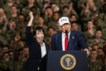 Japanese Prime Minister Sanae Takaichi raises her fist as U.S. President Donald Trump speaks to Navy personnel aboard the USS George Washington at Yokosuka naval base in Kanagawa Prefecture in late October. (Photo: AFP)