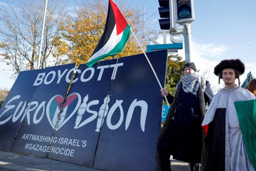 Pro-Palestinian protestors hold a flag and a banner outside the Irish public service broadcaster television studios to call for an Irish boycott of the 2026 Eurovision Song Contest if there is Israeli participation, in Dublin, on November 1, 2025.