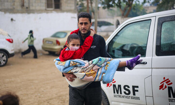 A Palestinian man brings a wounded child to MSF's clinic in Rafah, Gaza Strip, in 2023 (MSF)