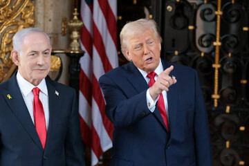 US President Donald Trump, who has threatened Iran with new military action, speaks to reporters alongside Israeli Prime Minister Benjamin Netanyahu outside the Mar‑a‑Lago resort in Florida on 29 December 2025 (Jonathan Ernst/Reuters).