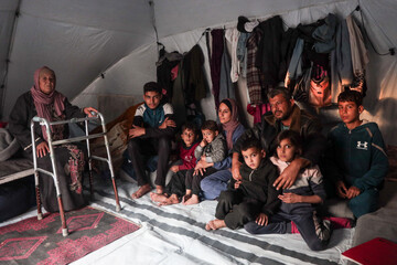Alaa Alzanin's family gather in a small tent sheltering them in Gaza City (Al Jazeera)