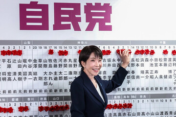 Takaichi places a red paper rose on the name of an elected candidate at the LDP headquarters during the House of Representatives election in Tokyo on February 8, 2026 (Getty Images)