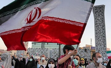 A child waves national flag in a sign of support for the Islamic Republic system