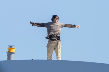 Guido Reichstadter standing high above the Anacostia River in Washington in protest the U.S. war on Iran