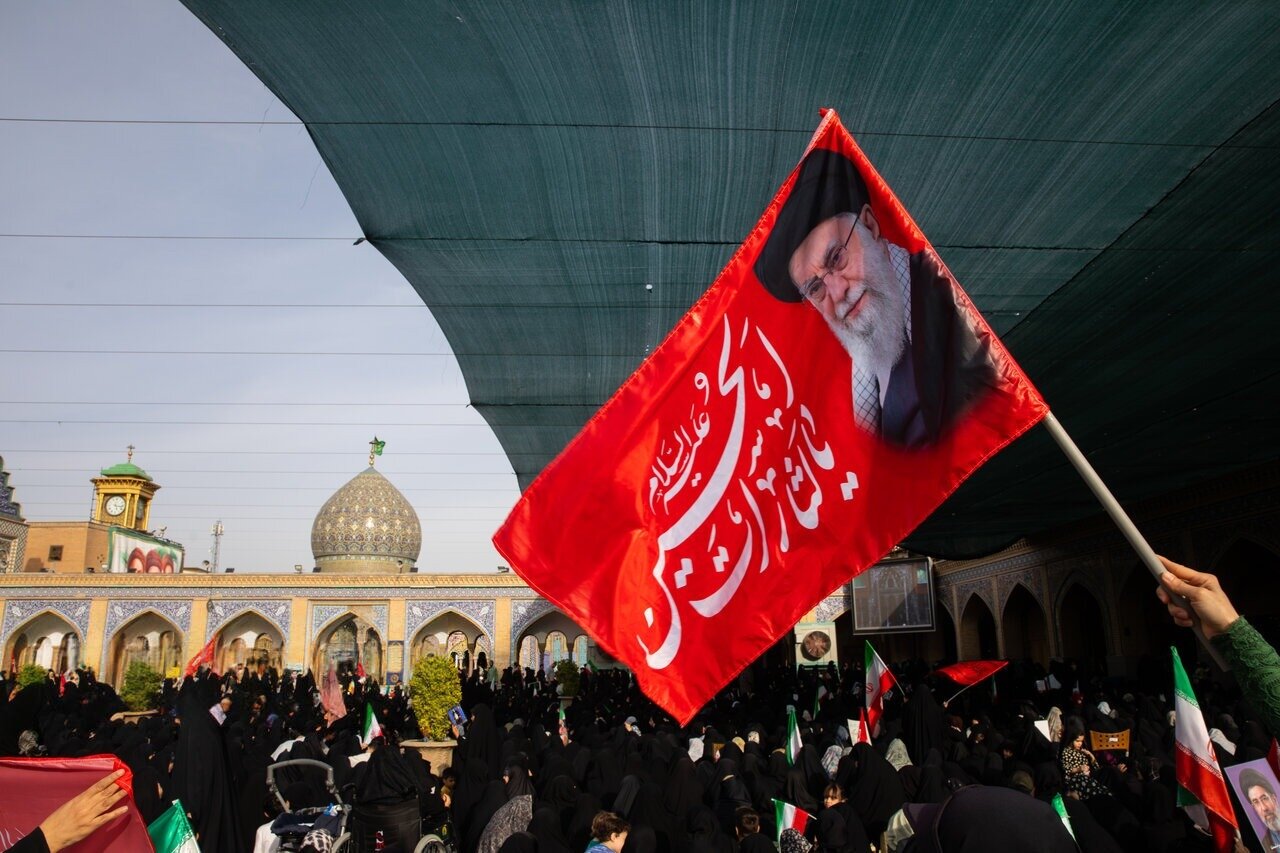 Iranians holding flags supporting the Islamic Republic