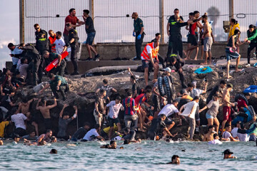 Migrants try to cross from Morocco into the Spanish enclave of Ceuta, July 30, 2026. (AP Photo/Antonio Sempere)