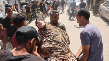 Palestinians carry a wounded woman away from the site of an Israeli strike that targeted the municipal police headquarters in Gaza City on 19 August 2026 (Omar al-Qattaa/AFP)