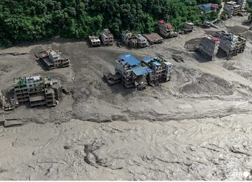 Houses lie partially submerged in muddy water along a riverside after flash floods at Trishuli Bazar in Nepal's Nuwakot district on Aug 26, 2026. (Photo: AFP/Prabin Ranabhat)